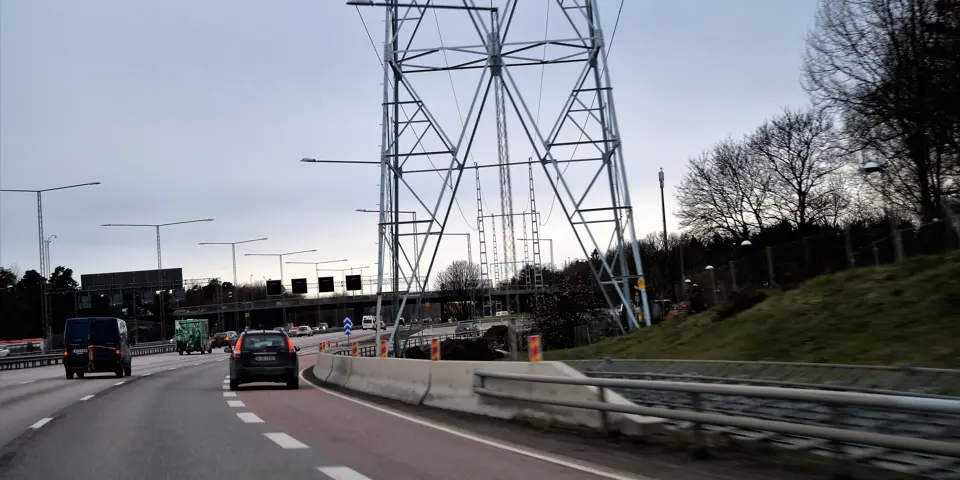 En trafikerad väg med en skyddsbarriär i betong till höger om körfältet